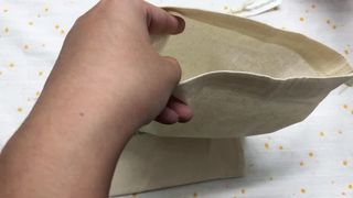 beige muslin cotton drawstring pouch with paper label
